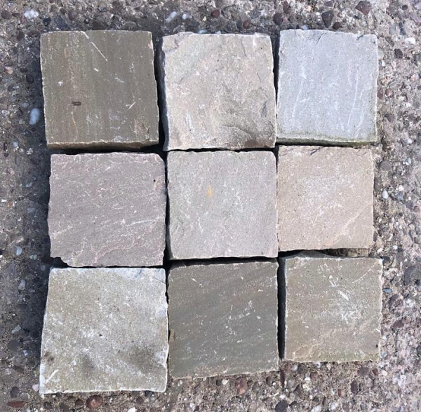 Raj Green Cobbles 100mmx100mm Raj Green mixed blend sandstone cobbles from India 100mm x 100mm cobbles with depth between 40mm and 60mm.  Raj Green cobble sets are the perfect way to finish your patio. Within these cobbles, you can achieve a visual outcome that features warm undertones or subtle shades of Green and Plum similar to the traditional York stone. These cobbles are naturally split with a riven surface. THE BENEFITS OF USING RECLAIMED RAJ GREEN COBBLES FOR YOUR PROJECT When embarking on a project, one of the foremost basic decisions to be made is what building materials to use. With the current increased awareness of sustainability, many individuals are turning to reclaimed materials in their projects.  There is a lot of choice available when it comes to reclaimed materials so lets look at some of the benefits of using reclaimed Raj Green cobbles. Cost Firstly when starting a new project, costs can be a major concern.  Using reclaimed Raj Green cobbles is an excellent choice for lowering expenditure on your project. These cobbles do not have any of the associated production costs attached to them that new materials do, allowing the prices to stay low. Environmentally friendly Secondly one of the largest advantages of using reclaimed granite cobbles is that they are an environmentally friendly option. The construction industry in the UK is a huge contributor to national waste and carbon emissions. Such emissions can come from extracting, producing, manufacturing and transporting building materials. By using reclaimed cobbles you can cut out a lot of this negative environmental impact as you are using pre-made materials, for instance. Adds character Thirdly using reclaimed materials for your project can be a fantastic way to add character and individuality. These materials can help create a unique finish, allowing you to make a truly original building. When used for paving, the variety of textures and tones available with reclaimed cobbles are sure to create an attractive and eye catching finish for those with an appreciation of history.